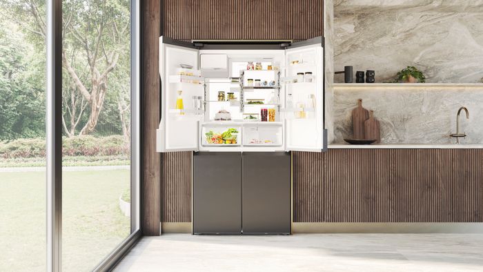 Frigorifero americano Siemens con porte aperte, installato in una cucina moderna, con alimenti organizzati