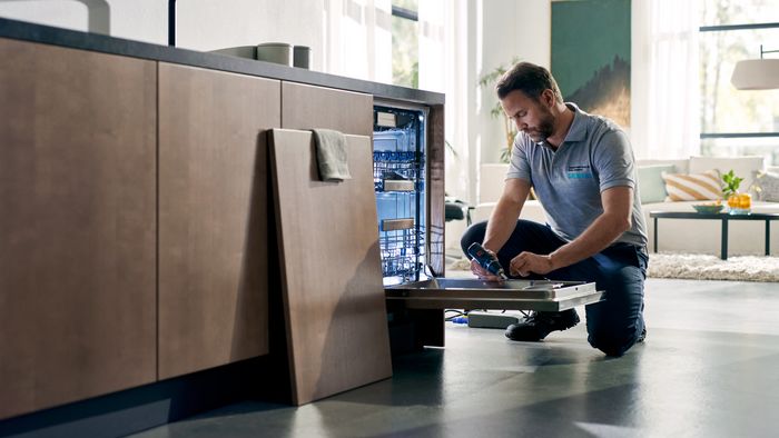 Técnico de Siemens reparando el electrodoméstico de un cliente