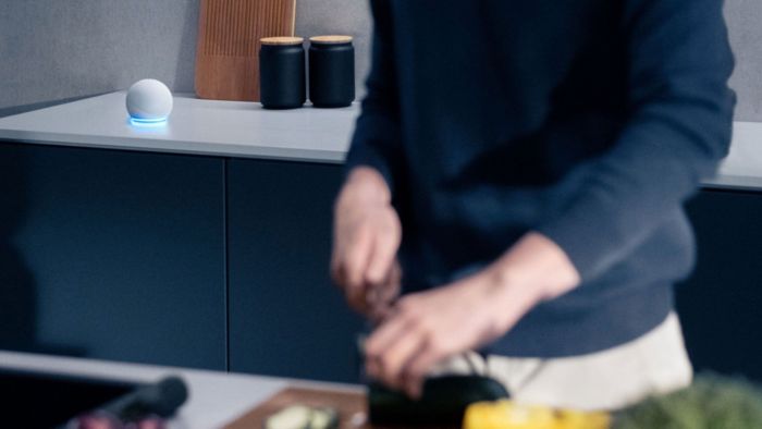 A person preparing food with an amazon echo in the background