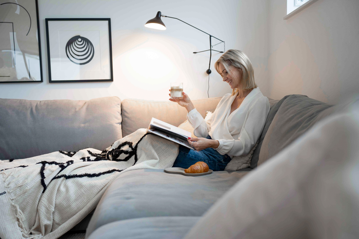 Heike zit op haar bank een boek te lezen en heeft koffie in haar hand. Als kind was koffie haar favoriete drankje. Een mooi koffiemoment.