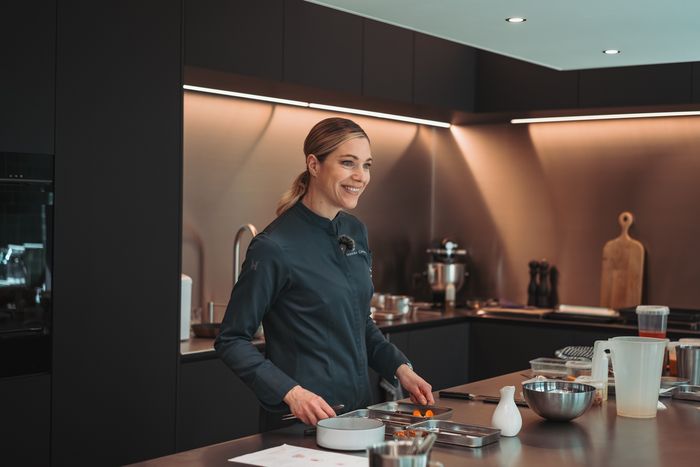 Frau in Koch Uniform bereiten Essen in der modernen K&uuml;che.