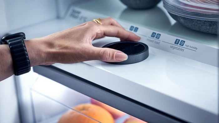 Mano ajustando la configuración del sensor de un frigorífico Siemens para controlar la humedad y la temperatura.