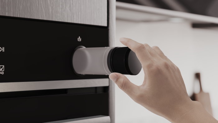 Närbild av en persons hand som tar ut en vattenbehållare ur ugnen.