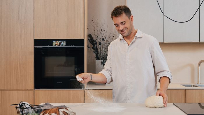 Jo Semola, der Brotfluencer, backt in moderner Küche mit Siemens Backofen.