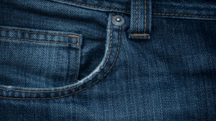 Primo piano di un tessuto denim che forma la tasca di un paio di jeans.