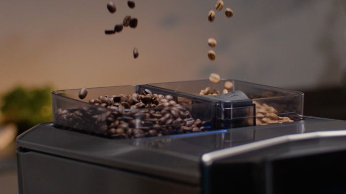 Kaffeb&oslash;nner med forskellig ristningsgrad falder ned i separate rum i en kaffemaskines tragt.