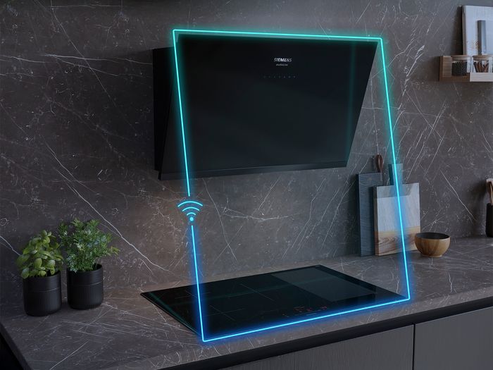 Cappa a parete sopra piano a induzione Siemens, evidenziati da una linea blu continua che indica la connettivit&agrave; smart in cucina 