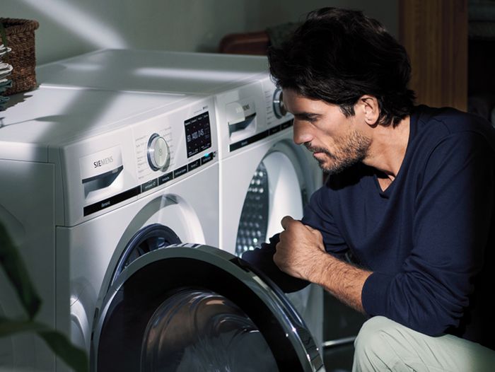 man som laddar en Siemens tvättmaskin