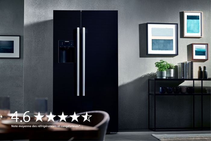 Un réfrigérateur Siemens noir et élégant avec des poignées métalliques se dresse contre un mur texturé, mettant en valeur un décor moderne et une note élevée de 4,6 étoiles.
