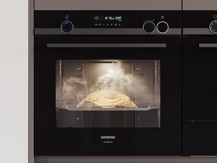 A Siemens steam oven displaying a loaf of bread baking, with glass door and digital controls visible above.