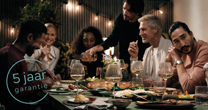 Man onderzoeken wasmachine, 2+3 jaar garantie logo zichtbaar.