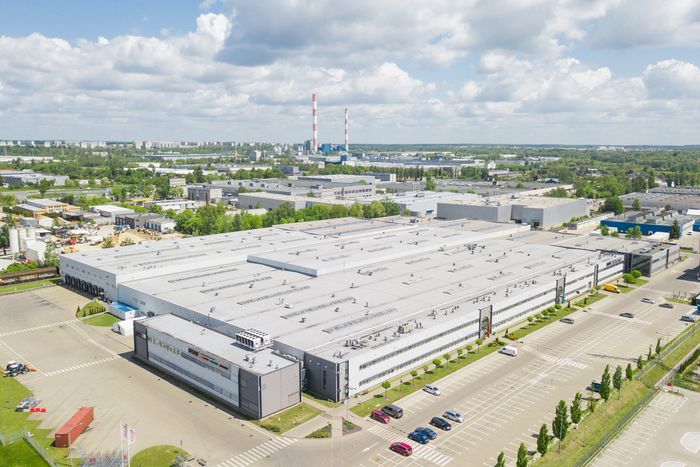 Zdjęcie fabryki z lotu ptaka, w tle kominy.