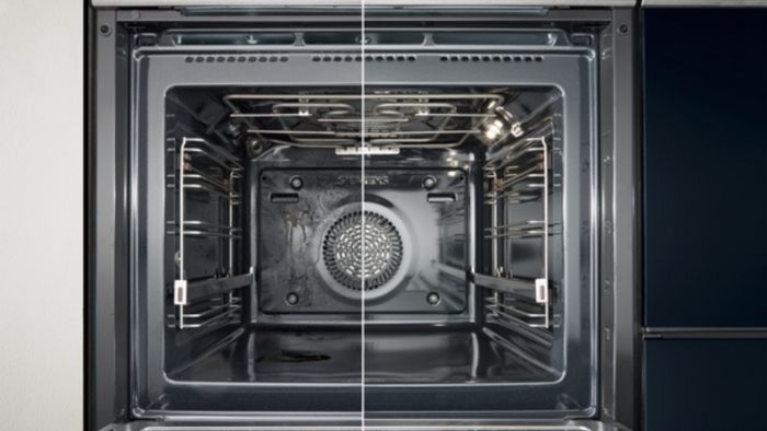 תמונת פנים של תנור אפייה מודרני, מצגת חצי מהתנור נקי וחצי מלוכלך. ניתן לראות את המדפים והמאוורר בחלק התחתון. העיצוב מסביר את התחזוקה הנדרשת להבטחת הפעלה אופטימלית.