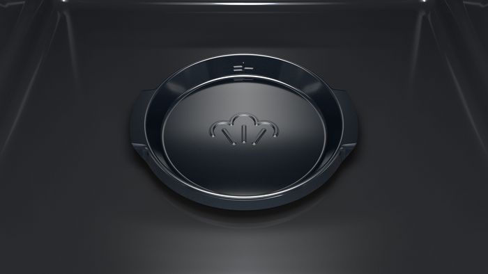 Närbild av ugnens botten, som visar en vattenbehållare.