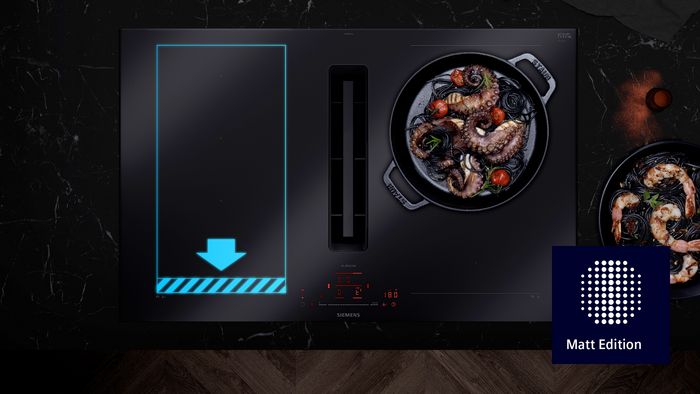 Sobre una vista cenital de una placa con extractor integrado en color negro mate, una infograf&iacute;a en azul muestra la superficie adicional de una zona XL de flexInducci&oacute;n.