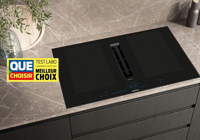 Appareil de cuisine noir avec tiroirs et panneau d'affichage sur un comptoir en marbre.