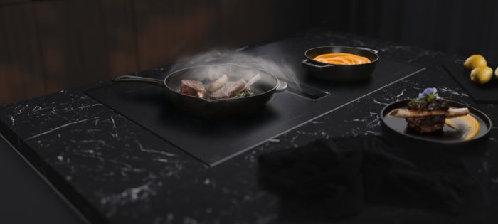 Questa cucina moderna &egrave; caratterizzata da una raffinata isola di colore nero, con un elegante rubinetto e forni Siemens integrati in una parete in legno scuro ravvivata dalle tonalit&agrave; di verde delle piante decorative.