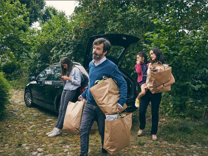 Family taking shopping bags out of car