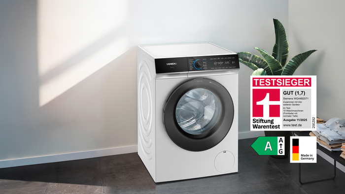 Siemens Waschmaschine WG44B2071 mit Stiftung Warentest Testsieger-Siegel GUT (1,7), Energielabel A und Made in Germany Hinweis in modernem Raum.