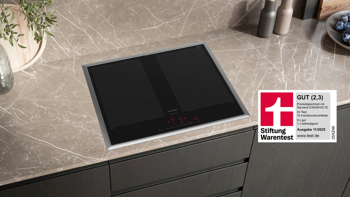 Siemens Induktionskochfeld EX645HXC1M auf einer Küchenarbeitsplatte aus Marmor mit Edelstahlrahmen, roter Touch-Bedienung und Stiftung Warentest Testsiegel „GUT (2,3)“ aus Ausgabe 11/2025.