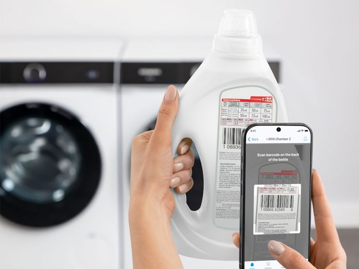 A person scanning a detergent bottle barcode using the i-DOS feature on a smartphone, connected by Home Connect.