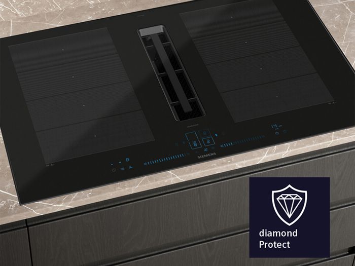 A black Siemens induction cooktop with an integrated downdraft extractor and blue digital controls, featuring flexible cooking zones and a "diamond Protect" logo overlay.