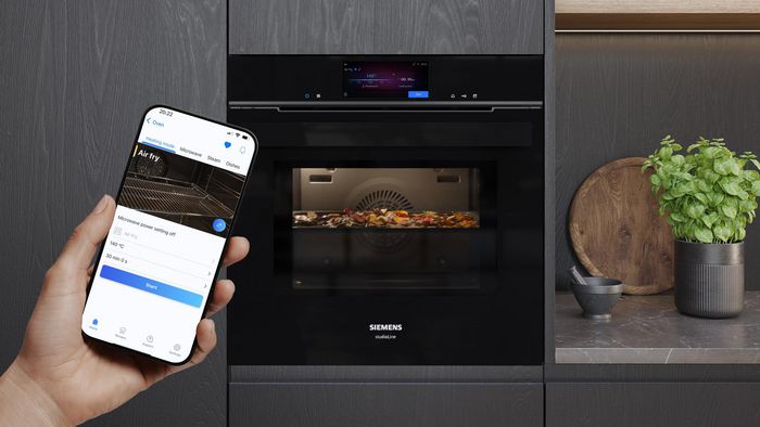 Person controlling smart oven with app
