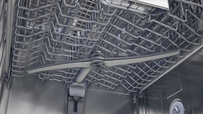 Interno di una lavastoviglie Siemens con braccio irroratore superiore e cestello, fotografati dal basso