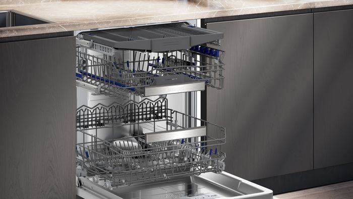 Lavastoviglie da incasso Siemens con cestelli estraibili, integrata in una cucina moderna con ante grigie e piano in marmo