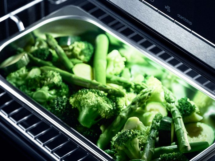 Forno a vapore da incasso Siemens con display digitale illuminato e teglia in acciaio contenente broccoli al vapore