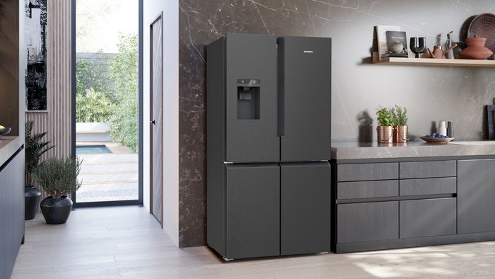 Frigor&iacute;fico Multidoor KF96DPXEA con dispensador de hielo y agua en una gran cocina conectada con salida a un jard&iacute;n