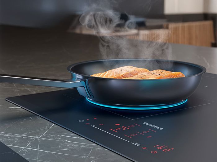 Padella su un piano cottura a induzione Siemens durante la cottura con regolazione precisa della temperatura