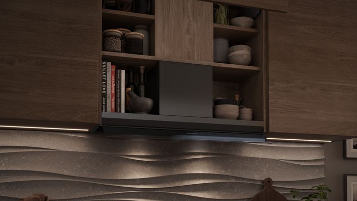 Cuisine moderne en bois avec &eacute;tag&egrave;res ouvertes contenant bocaux et vaisselle, hotte encastr&eacute;e au-dessus d&rsquo;une plaque &agrave; induction, cr&eacute;dence textur&eacute;e en vagues &eacute;clair&eacute;e, ustensiles en bois et plante en pot.