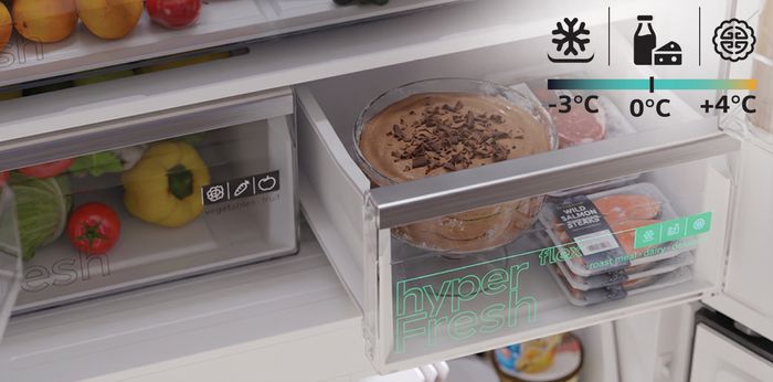 An open refrigerator drawer labeled "hyperFresh" containing food like salmon steaks and a dessert, with temperature indicators ranging from -3&deg;C to +4&deg;C.