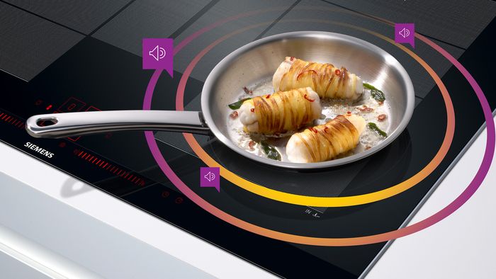 Cooking sensor hob with graphic overlay showing sound form frying pan with bacon wrapped tuna steaks