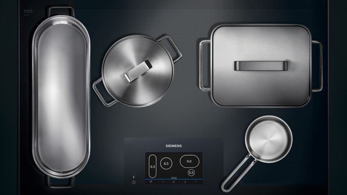top view of free induction hob with variety of pots and pans on hob
