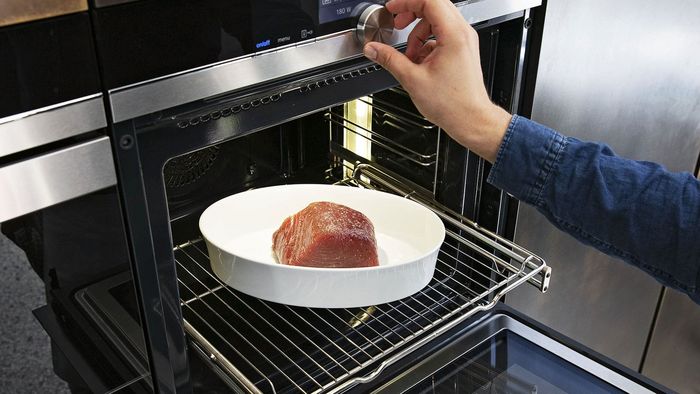 Una fuente redunda con un grueso lomo de at&uacute;n a punto de ser introducida en el horno