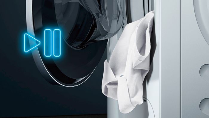 Wäsche ragt aus geöffneter Siemens Waschmaschine; Video startet Info zu Nachlegefunktion von Siemens Waschmaschinen 