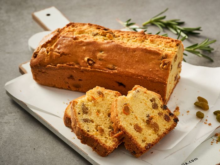 Plumcake con canditi su vassoio, con due fette tagliate