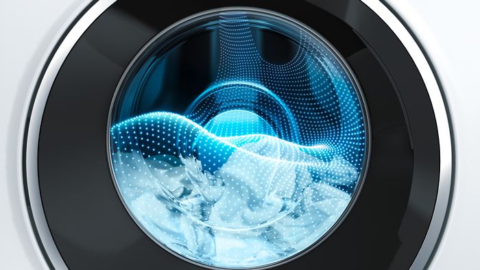 Interior of washing machine containing laundry and with holographic water overlay.