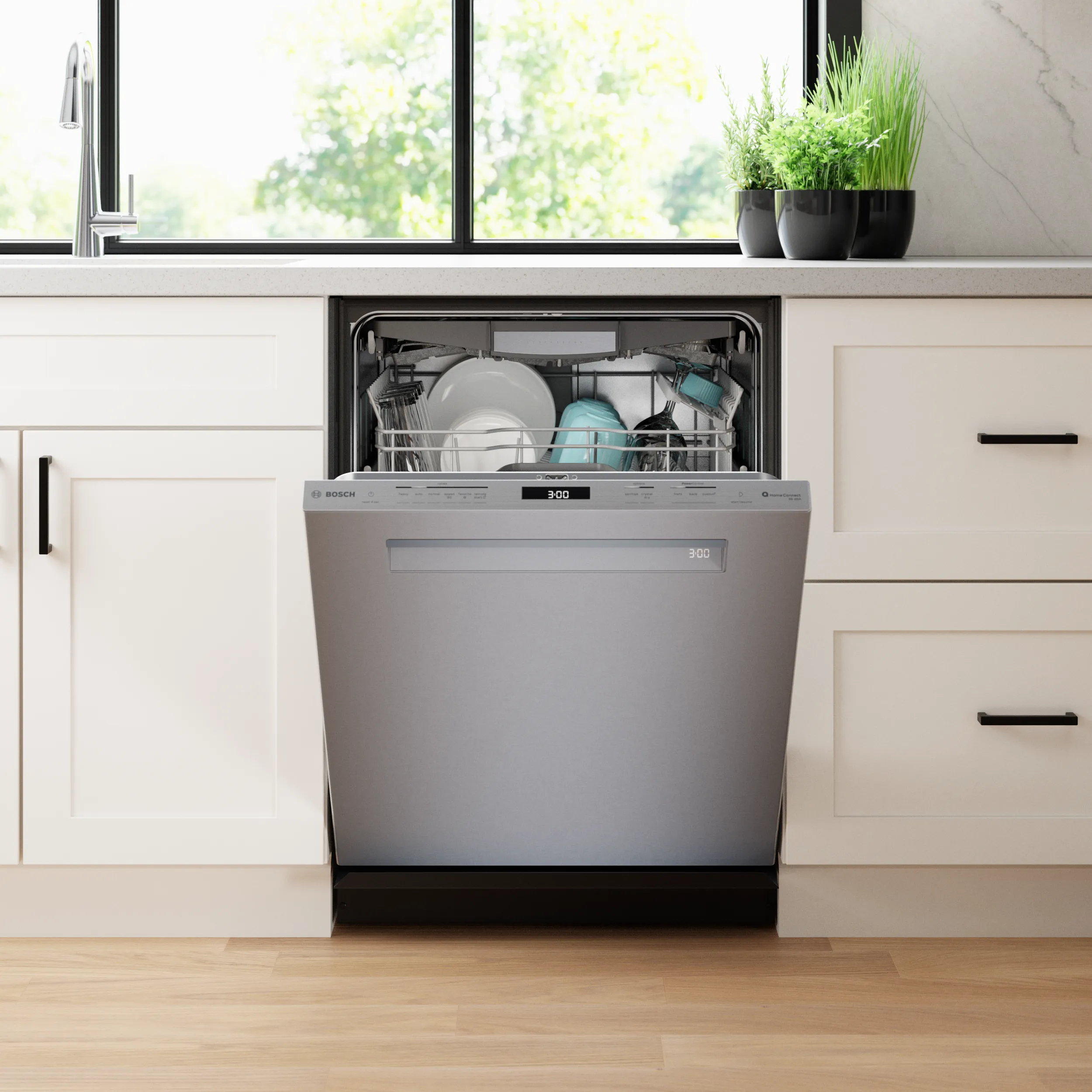 Bosch Benchmark dishwasher open in kitchen, loaded with dishes near a countertop with plants.